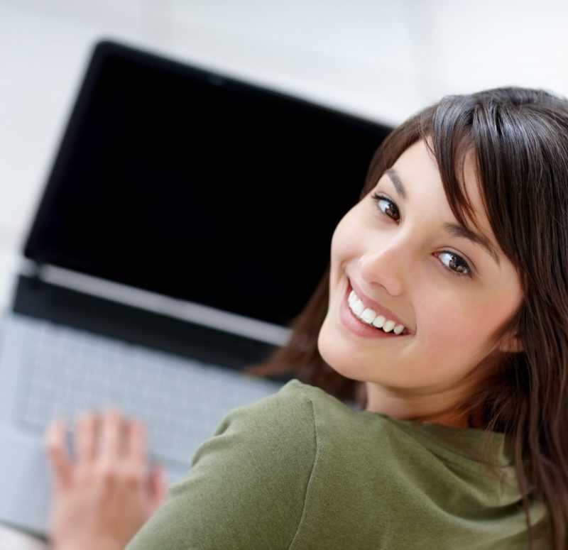 Portrait of a happy young female using a laptop